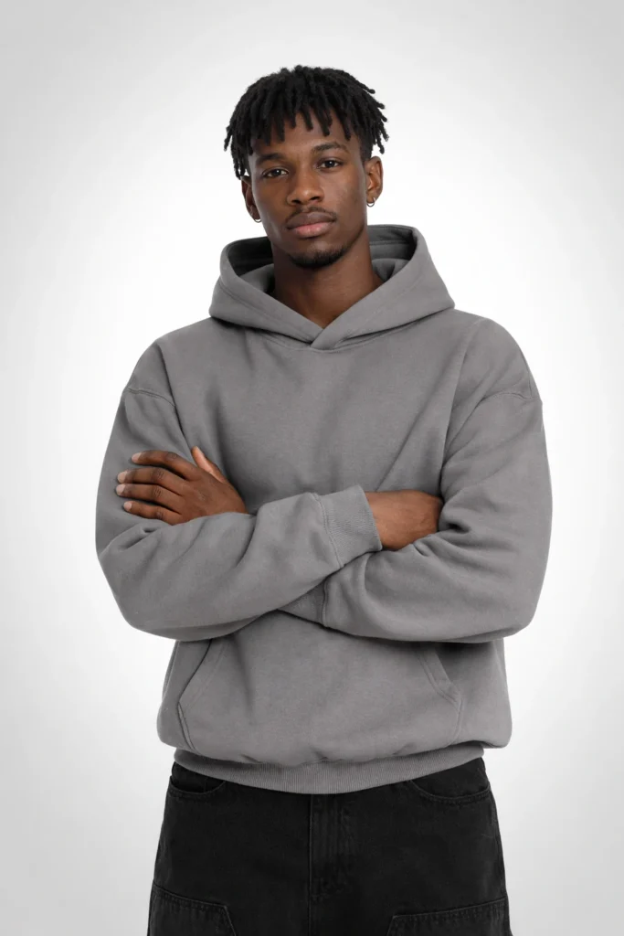 A clean studio image featuring a men’s grey pullover hoodie with a structured yet relaxed fit. Designed with a classic hood, ribbed cuffs and hem, and a front kangaroo pocket, this hoodie delivers a modern streetwear look with everyday comfort. The neutral grey tone makes it ideal for casual collections, minimalist fashion brands, and private label hoodie manufacturing focused on timeless design, soft fleece texture, and versatile wear.